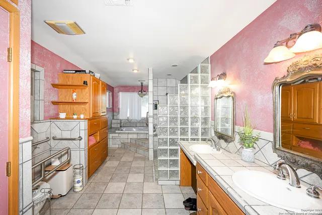 a large bathroom with a granite countertop double vanity sink a mirror and a shower