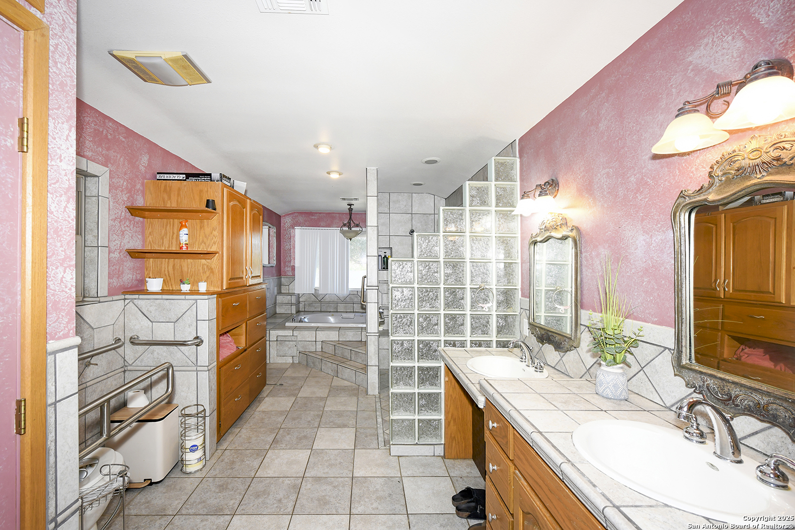 4720 Rakowitz Road Adkins, TX 78101 - Photo 13 of 35 a large bathroom with a granite countertop double vanity sink a mirror and a shower