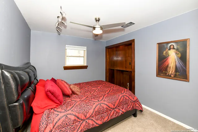 a bedroom with a large bed and a chandelier