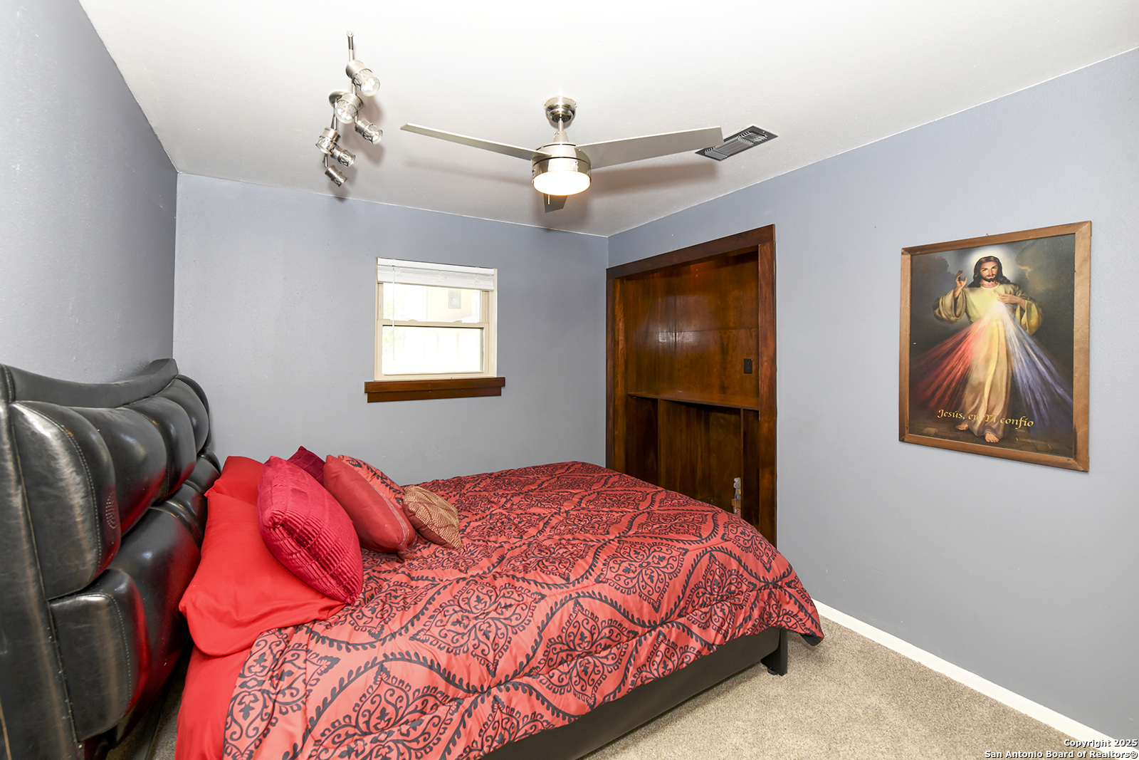 4720 Rakowitz Road Adkins, TX 78101 - Photo 16 of 35 a bedroom with a large bed and a chandelier