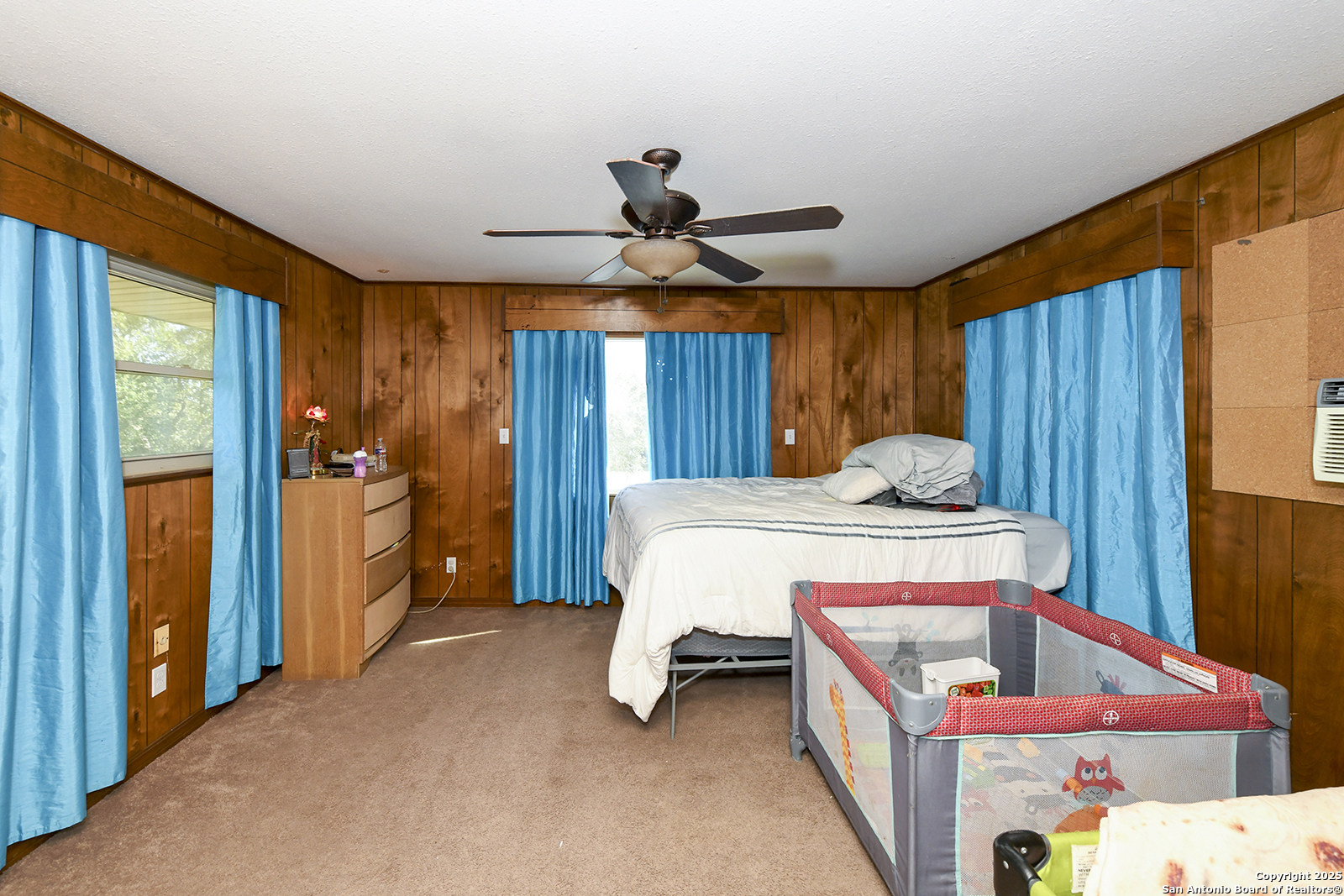 4720 Rakowitz Road Adkins, TX 78101 - Photo 20 of 35 a bedroom with a bed and a chandelier