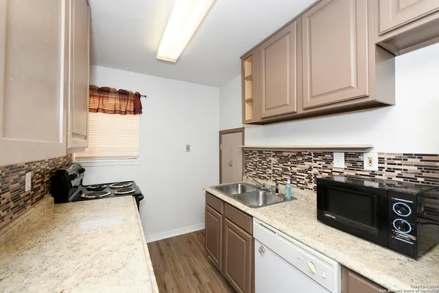 a kitchen with stainless steel appliances granite countertop a stove a sink and a microwave