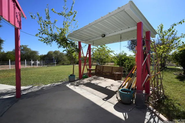 a view of a patio with a table and chairs and potted plants