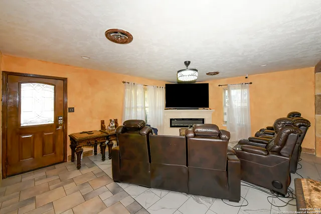 a living room with furniture a flat screen tv and kitchen view