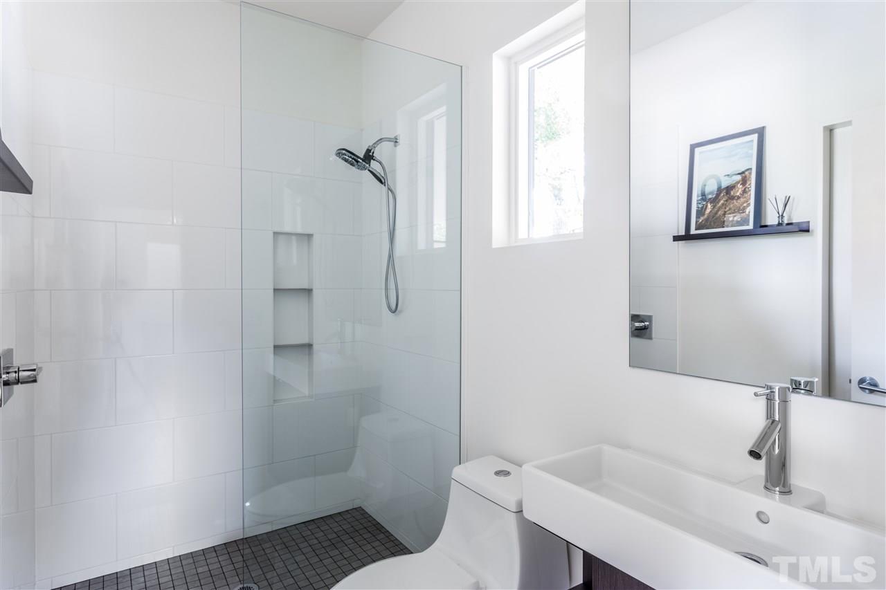 567 New Bern Avenue Raleigh, NC 27601 - Photo 13 of 30 a bathroom with a sink and mirror