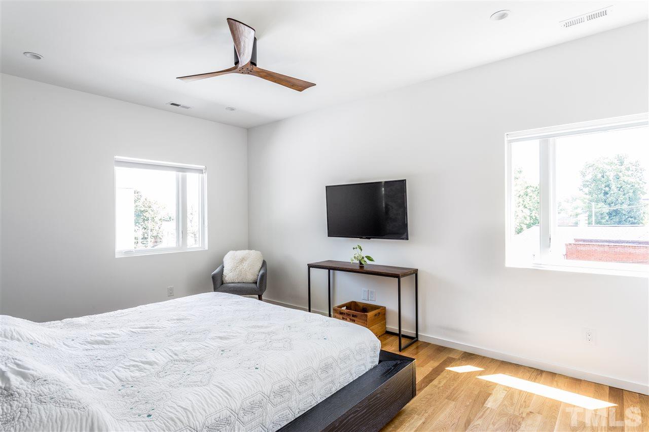 567 New Bern Avenue Raleigh, NC 27601 - Photo 15 of 30 a bedroom with a bed and a flat screen tv