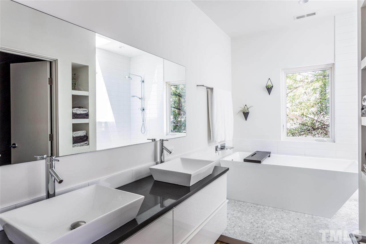 567 New Bern Avenue Raleigh, NC 27601 - Photo 18 of 30 a bathroom with a tub sink and mirror