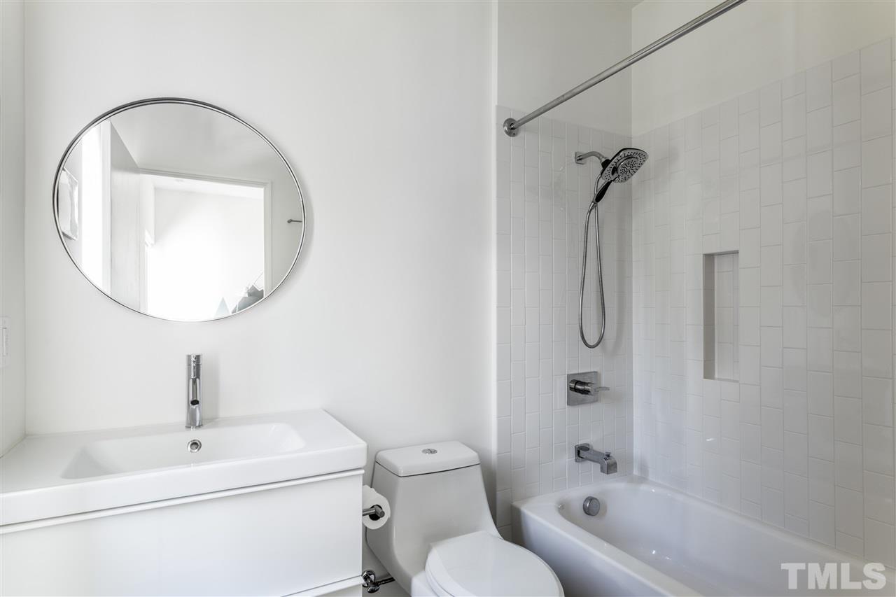 567 New Bern Avenue Raleigh, NC 27601 - Photo 21 of 30 a bathroom with a toilet sink and mirror