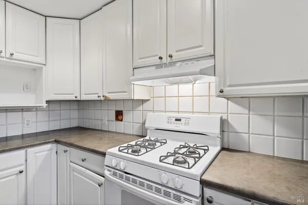 a kitchen with granite countertop a stove a sink and dishwasher