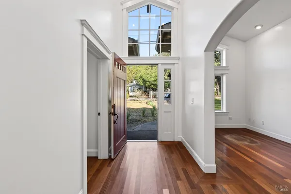 a view of a hallway with wooden floor and a bathroom