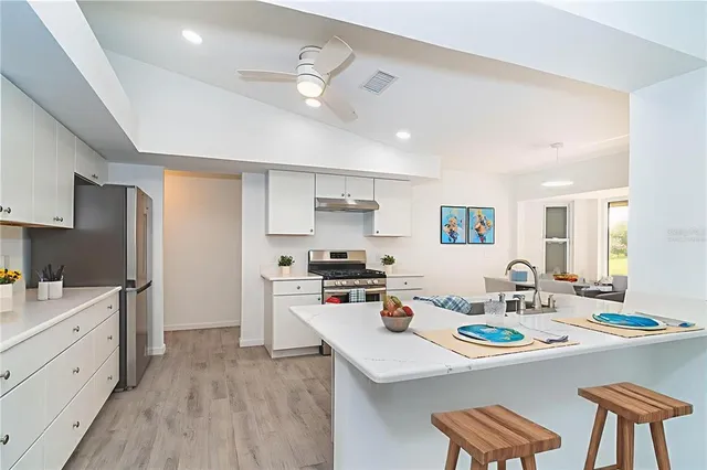 a kitchen with granite countertop a stove and a wooden floor