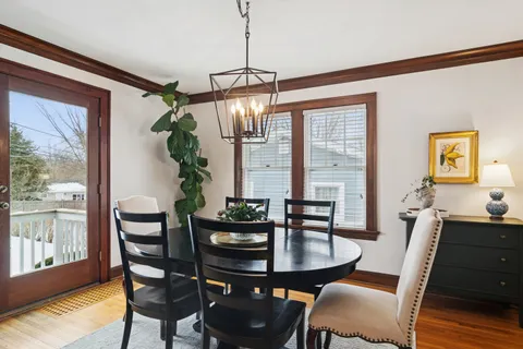 a dining room with furniture a chandelier and wooden floor