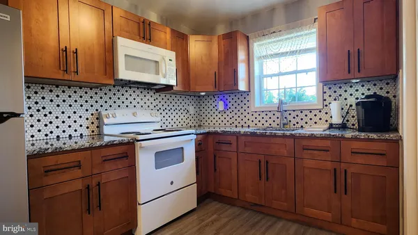 a kitchen with stainless steel appliances granite countertop a sink a stove and cabinets