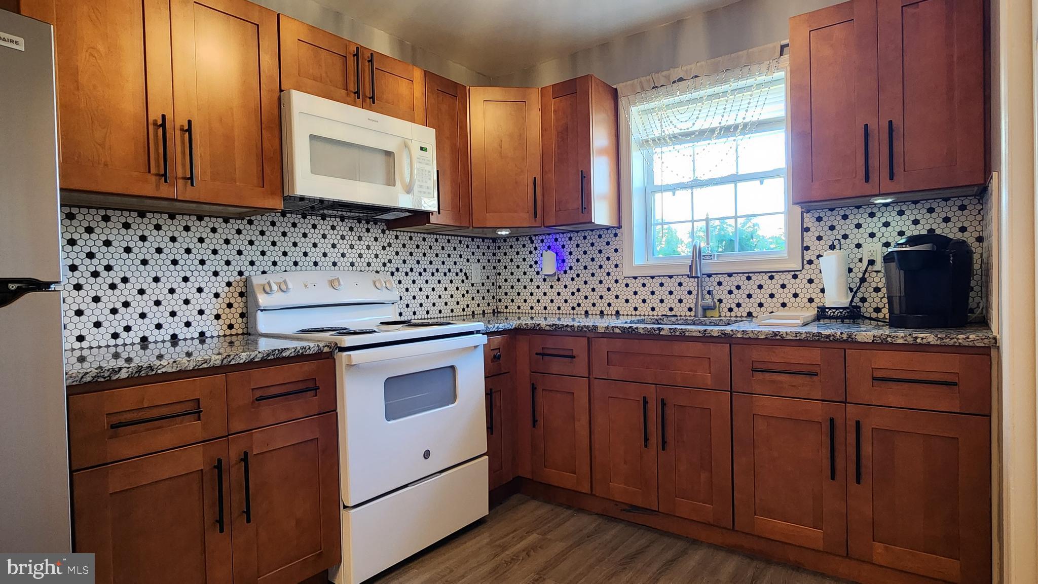 520 Bay Street Berlin, MD 21811 - Photo 7 of 22 a kitchen with stainless steel appliances granite countertop a sink a stove and cabinets