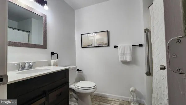a bathroom with a sink mirror vanity and toilet
