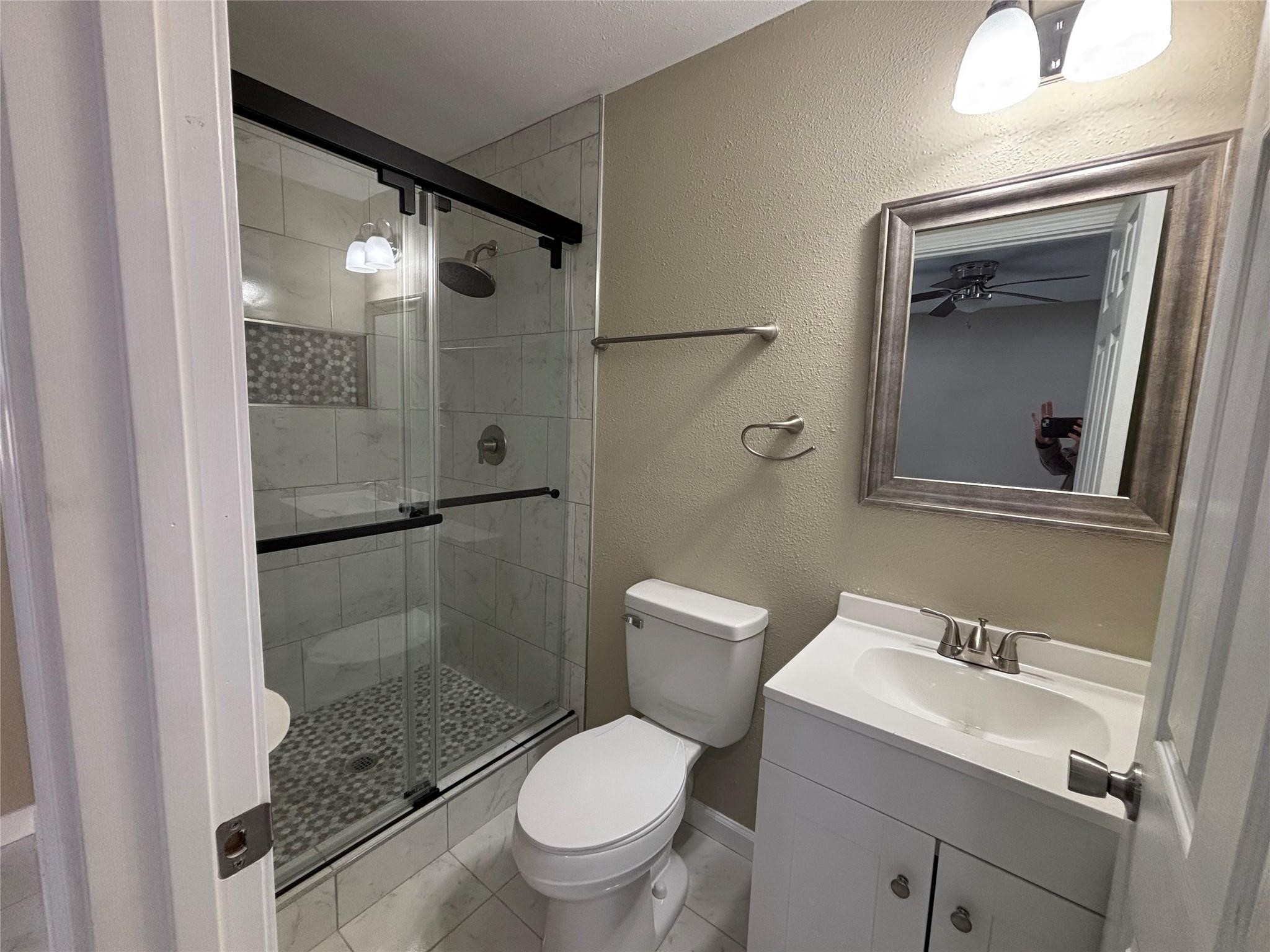 1401 Austin Street La Marque, TX 77568 - Photo 14 of 16 a bathroom with a granite countertop toilet sink and shower