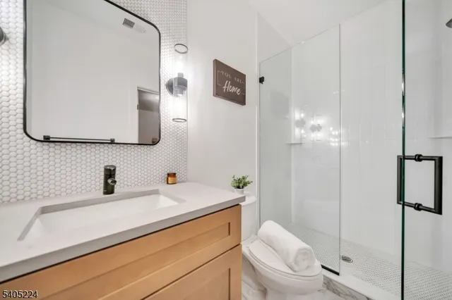 a bathroom with a sink a toilet and mirror