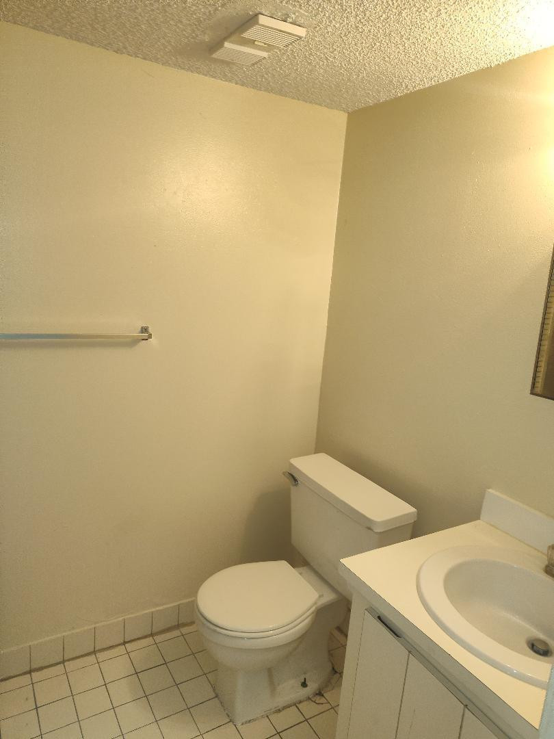 2293 Northwest 59th Way Lauderhill, FL 33313 - Photo 5 of 9 a white toilet sitting next to a white sink and vanity