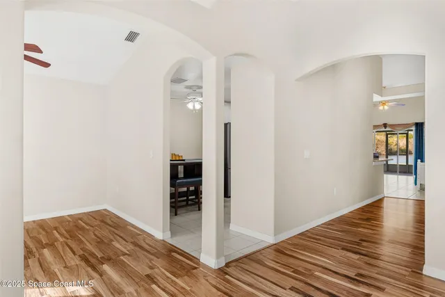an empty room with a window and a ceiling fan