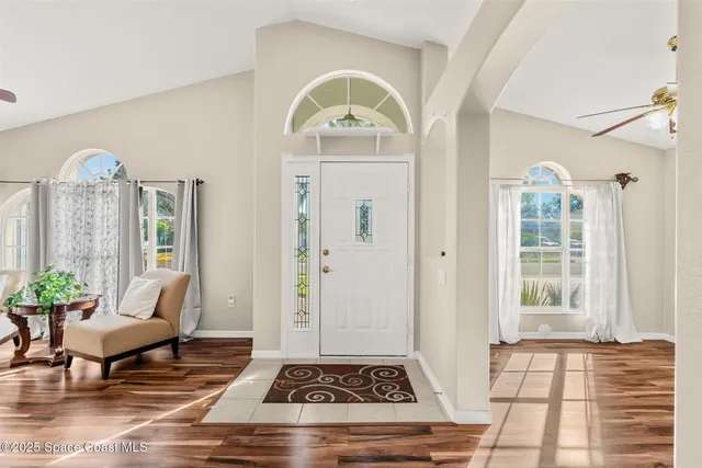 a living room with furniture a chandelier and a rug