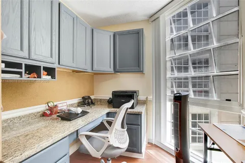 a kitchen with granite countertop a stove a oven a dining table and chairs