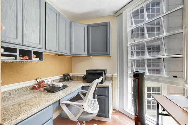 a kitchen with granite countertop a stove a oven a dining table and chairs