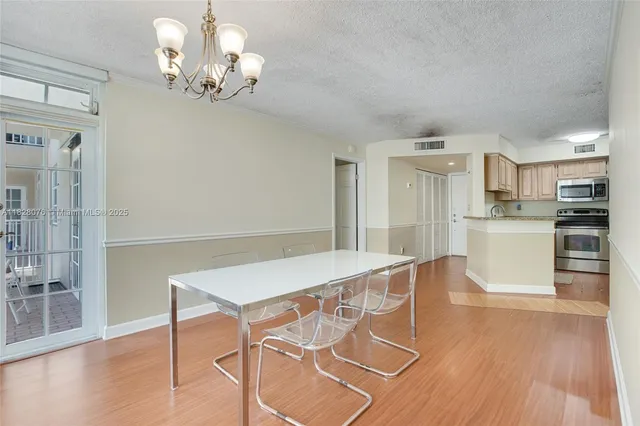 a view of a dining room with furniture wooden floor and chandelier