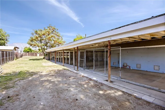 a view of a house with a yard and large trees
