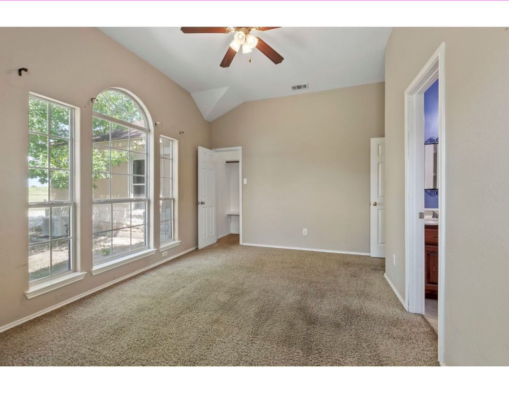 12015 Arnhamn Lane Manor, TX 78653 - Photo 26 of 35 a view interior of a house with wooden floor a ceiling fan and windows