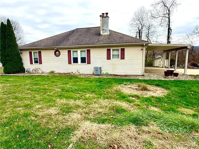 a view of a house with a yard and sitting area