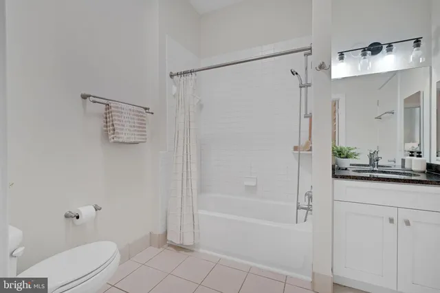 a bathroom with a granite countertop sink a toilet and shower