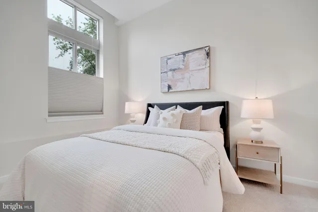 a large bed sitting in a bedroom next to a window