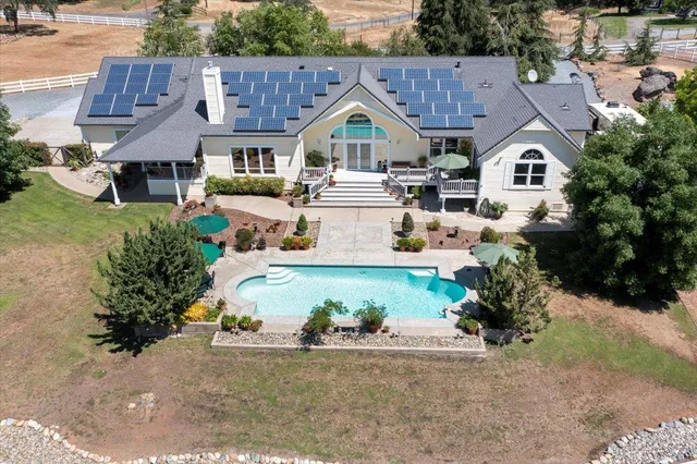 an aerial view of a house with a yard and a fountain