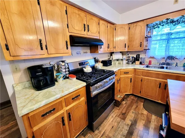 a kitchen with a sink a stove and cabinets