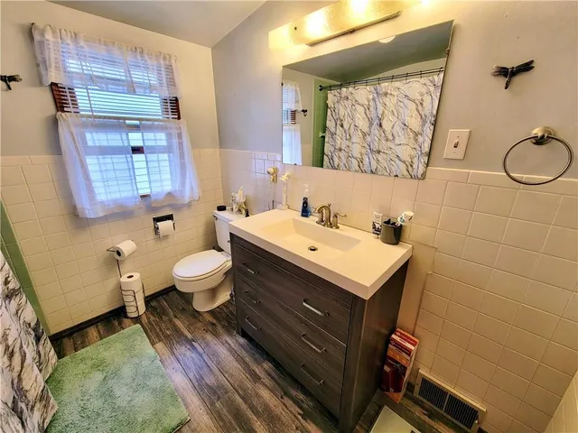 a bathroom with a sink mirror vanity and toilet