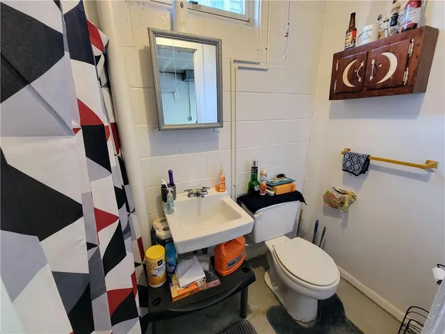 a bathroom with a sink a toilet and shower curtain