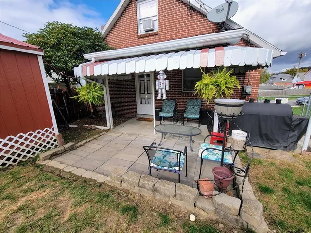 a backyard of a house with table and chairs