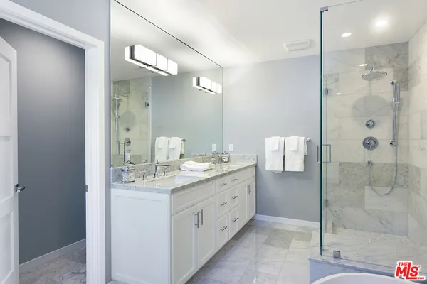 a bathroom with a shower sink and mirror