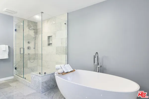 a white bath tub sitting next to a shower
