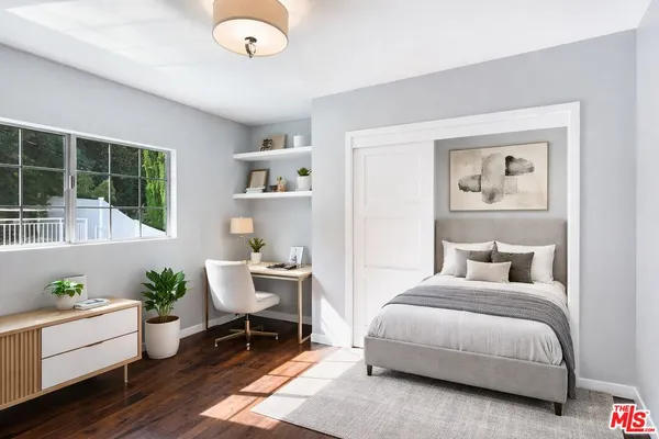 a bedroom with a bed and a potted plant