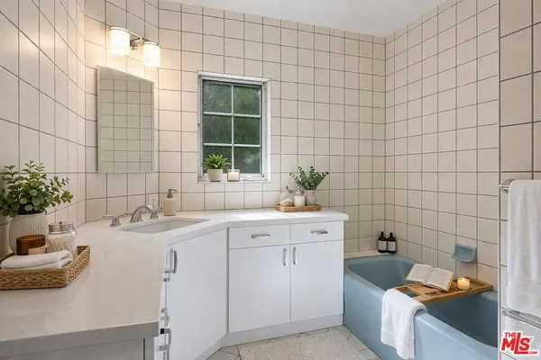 a bathroom with a tub sink toilet and mirror