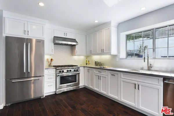 a kitchen with granite countertop stainless steel appliances and wooden cabinets