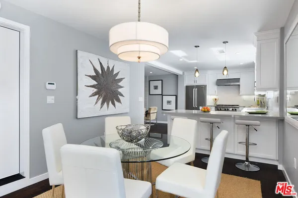 a kitchen with a dining table chairs sink and cabinets