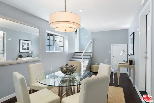 a dining room with furniture a chandelier and wooden floor