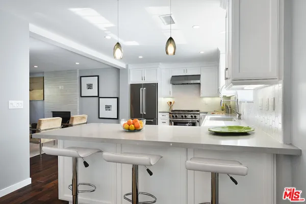 a kitchen with a sink a stove and chairs
