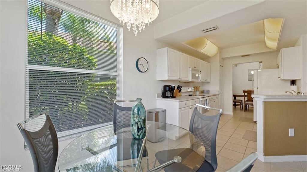 9582 Hemingway Lane, Unit 3402 Fort Myers, FL 33913 - Photo 11 of 27 a living room with furniture a chandelier and a dining table