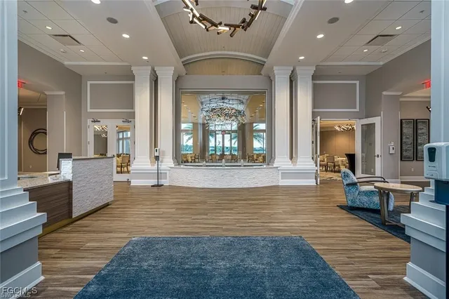 a living room with furniture large window and wooden floor