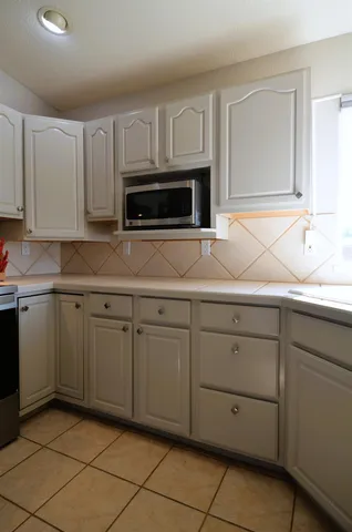 a kitchen with white cabinets a sink and dishwasher