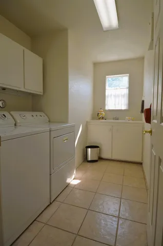 a utility room with cabinets dryer and washer