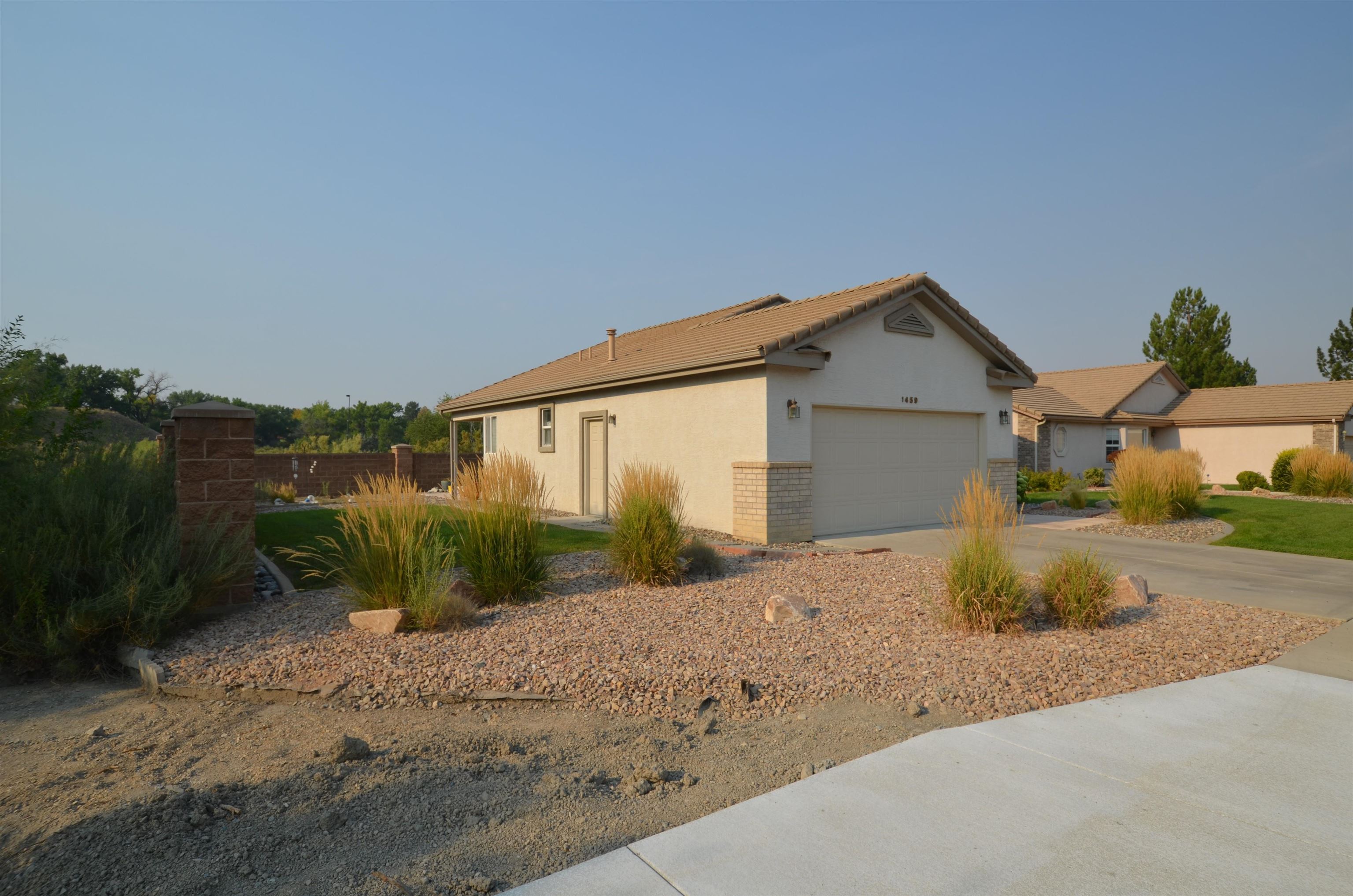 1459 Racquet Way Grand Junction, CO 81506 - Photo 3 of 42 a front view of a house with a yard and garage